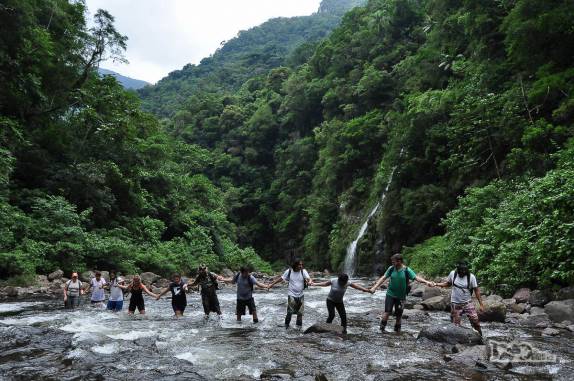 Todos de mãos dadas, travessia de rio na trilha do Rio do Boi, no canyon Itaimbezinho, em Praia Grande, em Santa Catarina
